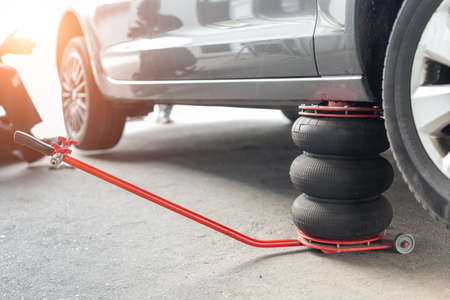 Car wheel repair shop outdoor ground . Seasonal winter tyre change at workshop. Vehicle tire repair, inspection and maintenance. Automotive garage with inflatable pneumatic air jacks. Copyspace textの写真素材