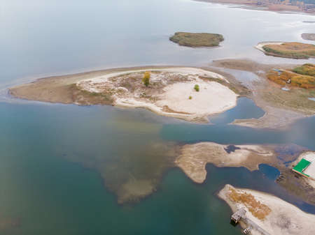 Scenic aerial drone birds eye view of swallow sand river or lake shore due to drought and water pond reservoir dam draining. Natural disaster of arid, warmand dry climate changeの写真素材