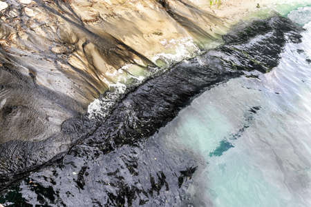 Beautiful sand sea blue water or lake beach polluted with black harmful toxic sewage chemicals....
