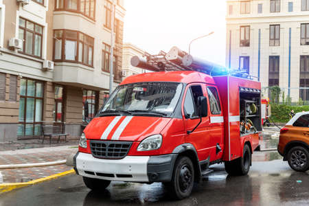 Small compact fire engine truck with ladder and safety equipment at accident in highrise tower...