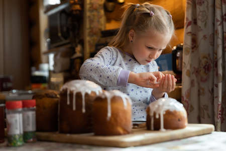 Kid help mom decorate Traditional eastern europe Russian and ukrainian Easter cake kulich decorated...