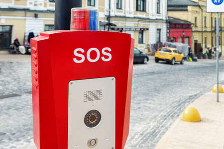 Red emergency police SOS call button alarm box with light bar, cctv camera and speaker device for urgent comunication on city street. Modern smart communication technology public space. Civil safetyの写真素材
