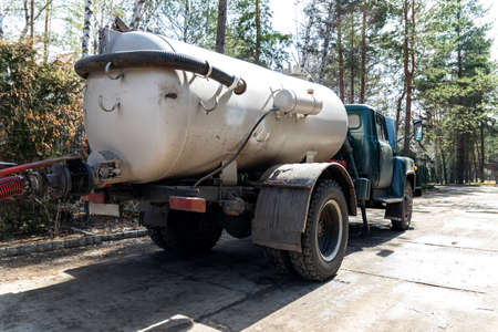Close-up pipe hose of sewage truck car engine emptying home sewerage tank. Septic cleaning vacuum...
