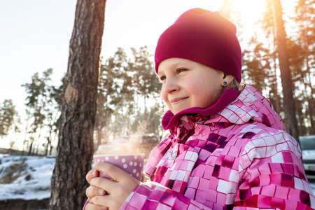 Cute adorable beautiful caucasian little kid girl enjoy walking holding paper cup with warm drink...
