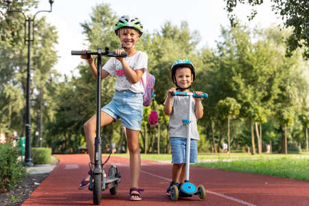 Portrait of two cute blond little caucasian sibling kids girl wear safety helmet enjoy having fun...
