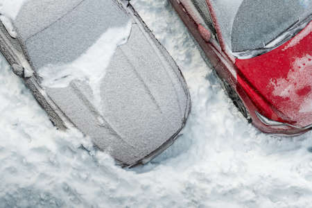 Top aerial view of apartment office building parking lot with many cars covered by snow stucked after heavy blizzard snowfall winter day. Snowdrifts and freezed vehicles. Extreme weather conditionsの写真素材