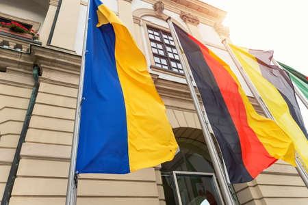 Big Ukraine Germany and Saxony Anhalt flags waving blowing by wing on Magdeburg city hall building facade. Ukrainian and Germany partnership, support and friendship conceptの写真素材