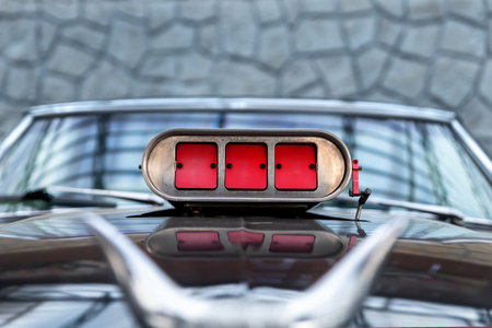 Close-up detail view of old classic vintage retro american supercharged muscle car red intake throttle valve on hood bonnet chrome horns mounted. Street power performance drag customs oldtimer autoの写真素材