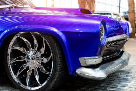 Many classic purple vintage old american cars parked in row at garage, exhibition of fest. Close-up detail view beautiful retro oldtimer vehicle hood, headlight, fender and shine chrome plated bumperの写真素材
