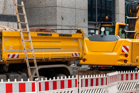 Sity street renovation rebuilding construction site with dump truck flasher excavator digging earth undeground infrastructure sewerage engineering system. Public municipal urban works sidewalk roadの写真素材
