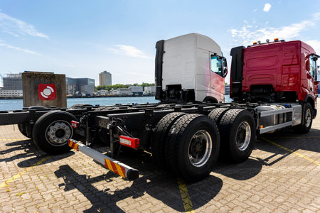 Back view many new heavy commercial cargo transport vehicles stand at port for export import...