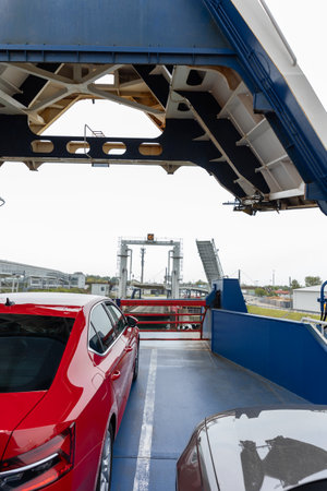 Front open door of passenger freight cargo ferry boat vessel ship with loaded cars and vehicles. Sea...