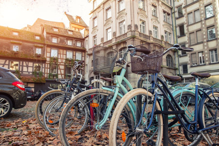 Many vintage modern retro bicycles parked at Alsace Strasbourg city street against medieval old...
