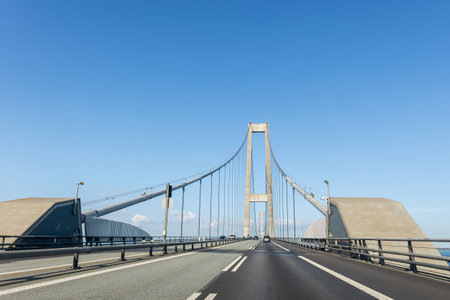 Great Belt or East Bridge Storebaelt from Sealand Funen danish island blue clear sky background. Driver view hanging suspension bridge construction on bright sunny day. European travel transportationの写真素材