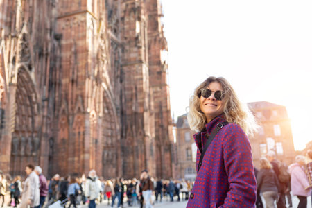 Portrait young beautiful happy smiling woman wear wool tweed coat enjoy walking Ill river embankment european Strasbourg city street on sunny day. Stylish female person urban lifestyleの写真素材