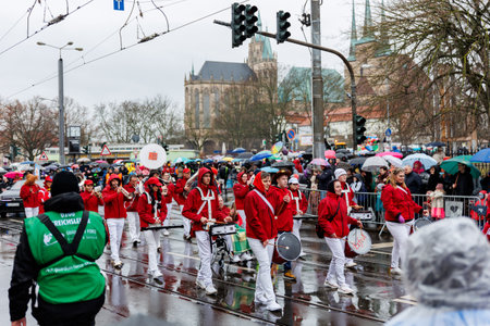 Erfurt, Germany - 11th February, 2024: Traditional german Carnival Fasching 2024 at Thuringia. People city street celebrate festival dancing having fun floating city center during heavy rain weatherのeditorial素材