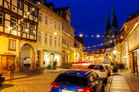 Charming Quedlinburg town evening street view illuminated with Christmas lights old St. Nicholas Church St. Nicholas Kirche background historical half-timbered houses facade. Festive city Germanの写真素材