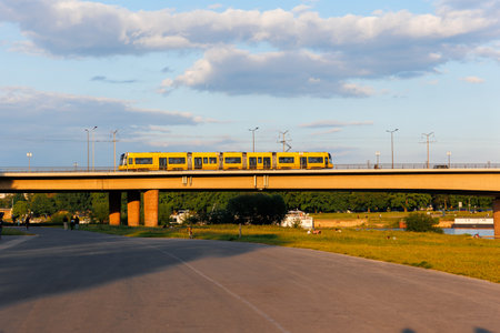 Yellow Tram Crossing Carola Bridge in Dresden at Sunsetの写真素材