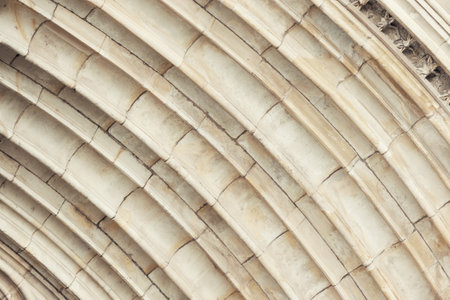 lose-up of historic classic stone arch showing detailed ribbed vault construction with weathered texture. Repeating curves emphasize Gothic architectural symmetry and craftsmanshipの写真素材