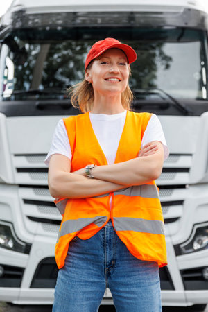 Portrait young adult happy smiling woman heavy truck driver modern cargo vehicle cabin background. Female person girl professional job career working driving freight engine lorry. Logistics industryの写真素材