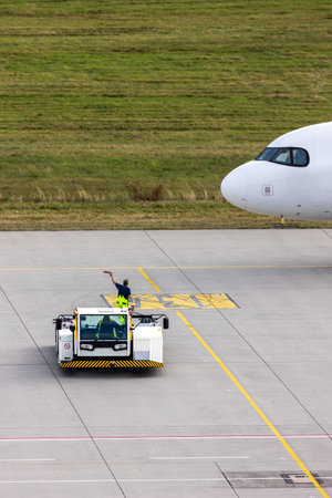 Modern regional jet aircraft towed by ground vehicle on airport taxiway tarmac under sunlight. Engine cockpit clearly visible crew performs technical operations before next scheduled flight airportの写真素材