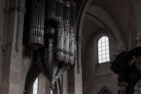 TRIER, GERMANY - Apr 20, 2025: Grand pipe organ in Trier Cathedral features ornate floral carvings and dramatic suspended structure rising above stone archesのeditorial素材