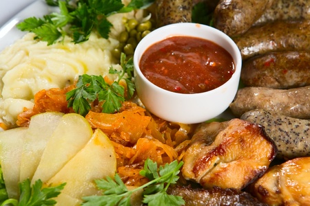 Grilled sausage with sauce and vegetablesの写真素材