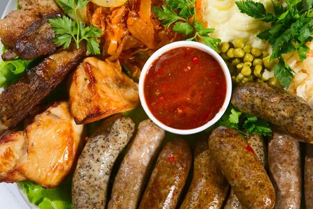 Grilled sausage with sauce and vegetablesの写真素材