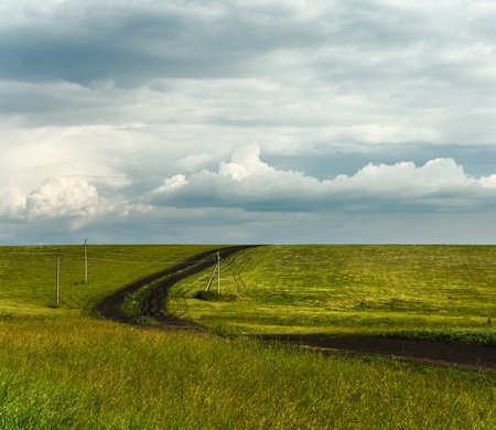 summer landscape with road and cloudy skyの写真素材