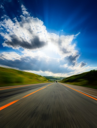 motion blurred road and cloudy blue skyの写真素材
