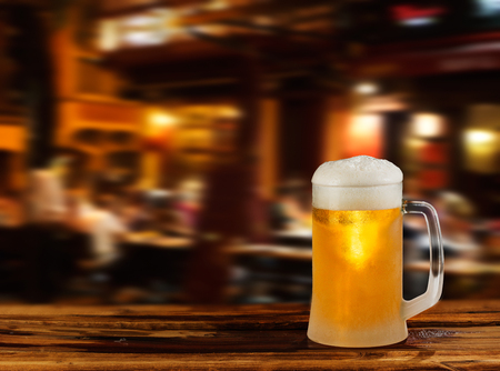 cold glass mug of beer with foam on the background of the streetの写真素材