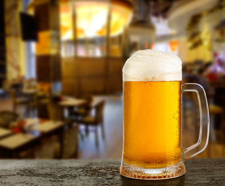 Mug with beer on the background of bar.の写真素材