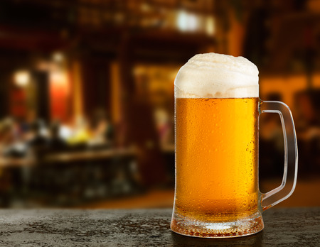 Mug with beer on the background of a outside bar.の写真素材