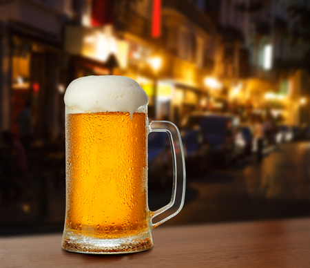 Mug with beer on the background of a outside bar.の写真素材