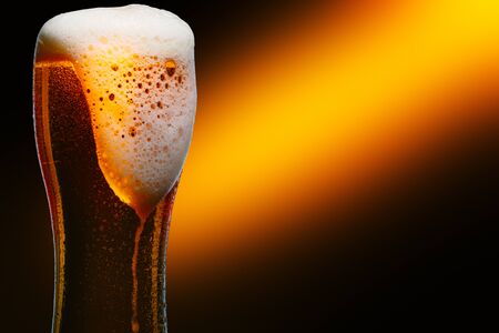 Glass of cold craft light beer on dark background.の写真素材