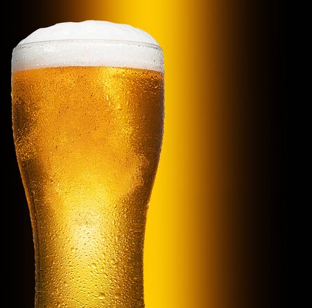 Glass of cold craft light beer on dark background.の写真素材