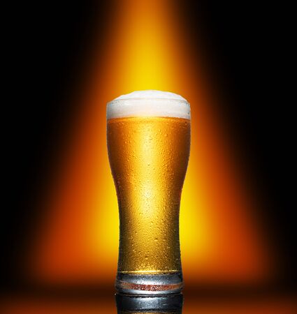 Glass of cold craft light beer on dark background.の写真素材