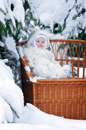 Small Kid with snowy branch on winewomen benchの写真素材