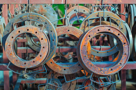 Rusted steel flanges are stored in a warehouse,  Industrial area of old factory の写真素材