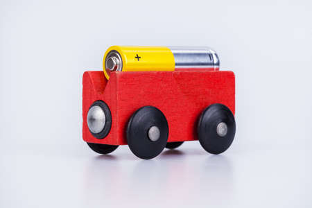 AA alkaline battery on a wood wagon isolated on white backgroundの写真素材