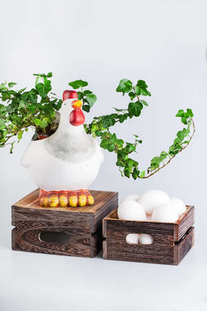sculpture of hen near  bio eggs in box isolated on whiteの写真素材