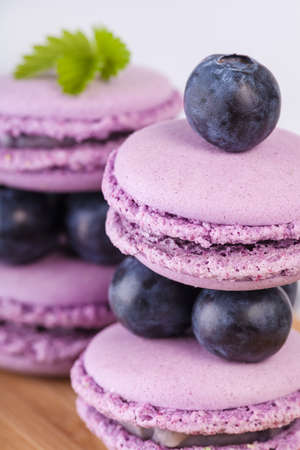 Traditional french macaroons with blueberries on the tableの写真素材