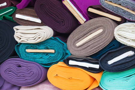 Rolls of fabric and textiles in a factory shop. Multi different colors and on the market.