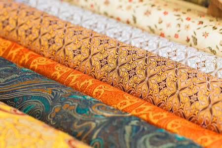 Rolls of fabric and textiles in a factory shop. Multi different colors and patterns on the marketの写真素材