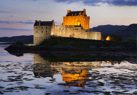 Eilean Donan Castle at Kyle reflecting itself into the water of Loch Duich and loch Alsh, during evening low tide in the Western Highlands of Scotland near Skye, UK.の写真素材
