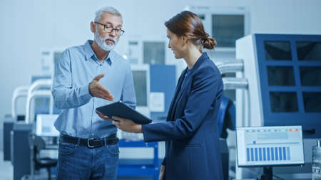 Inside Office: Digital Engineering Professional Working on Personal Computer, Designing 3D Component in CAD SoftwareIn Factory Workshop: Male and Female Engineers Use Tablet Computer and Talkの写真素材