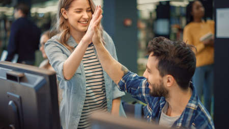 University Library: Bright Caucasian Girl and Talented Boy Study for Exams and Give High Five after...