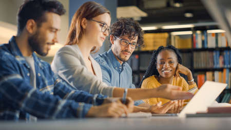 Diverse Team of Young Brilliant Entrepreneurs and Office Specialists Have a Meeting, Talking, Using Digital Tablet Computer, Finding Solutions and Solving Problems. Talented Young People Workingの写真素材