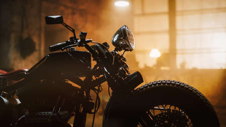 Custom Bobber Motorbike Standing in an Authentic Creative Workshop. Vintage Style Motorcycle Under Warm Lamp Light in a Garage. Profile View.の写真素材
