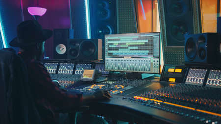 Portrait of Audio Engineer Working in Music Recording Studio, Uses Mixing Board Create Modern Sound....